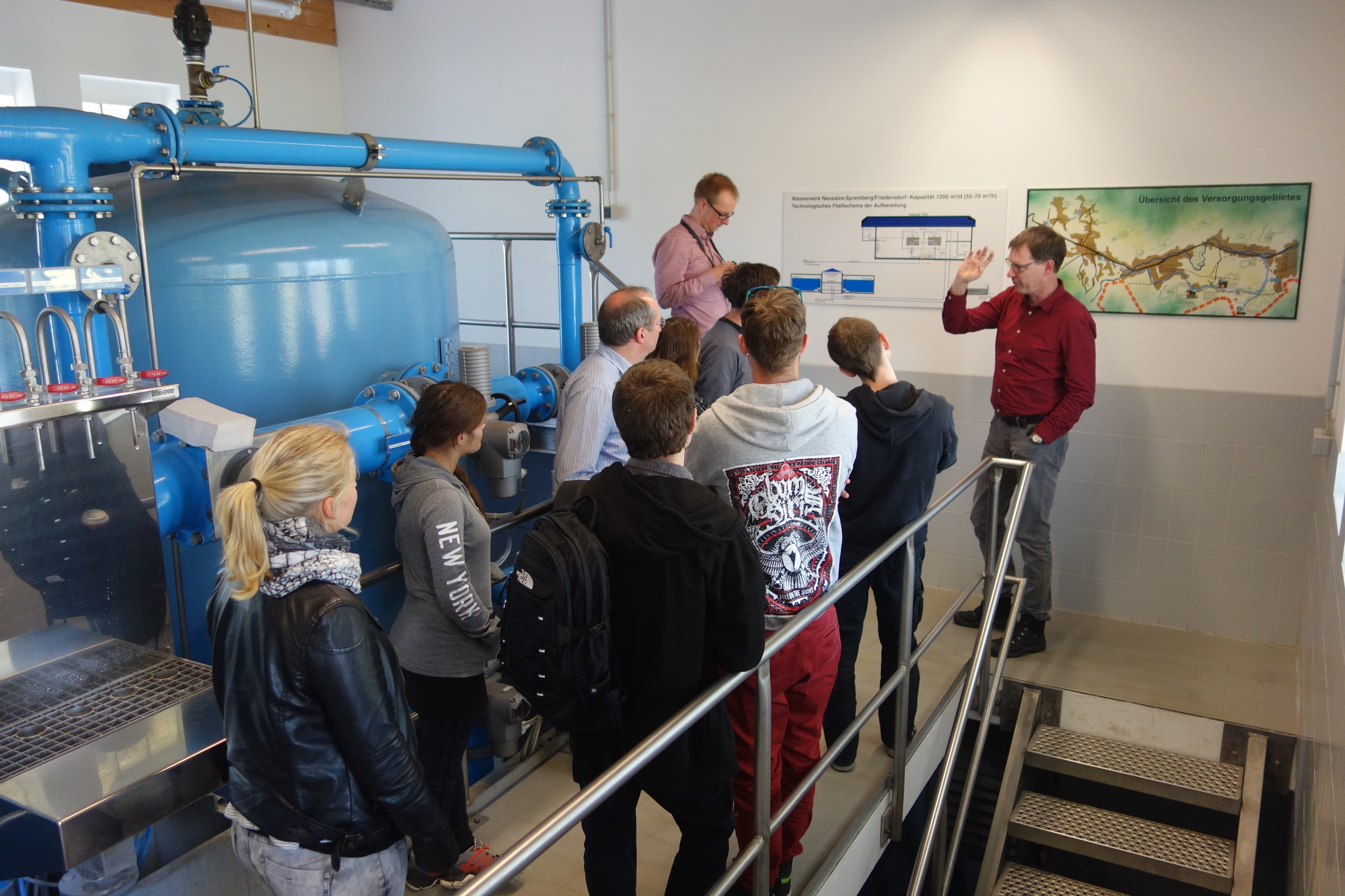 Students standing in front of water tanks in a water treatment plant