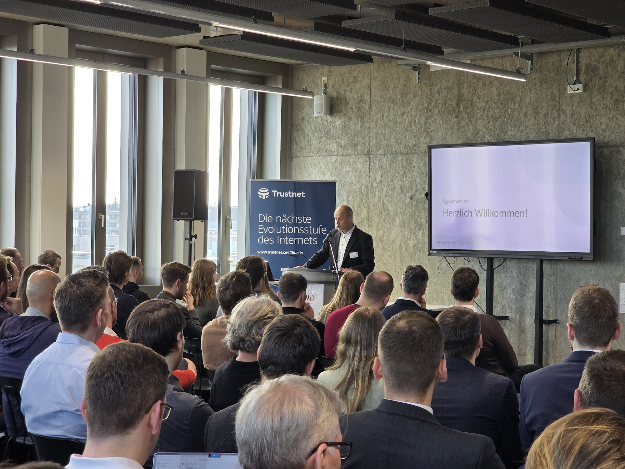 Veranstaltungsraum mit einem Vortragenden und Publikum