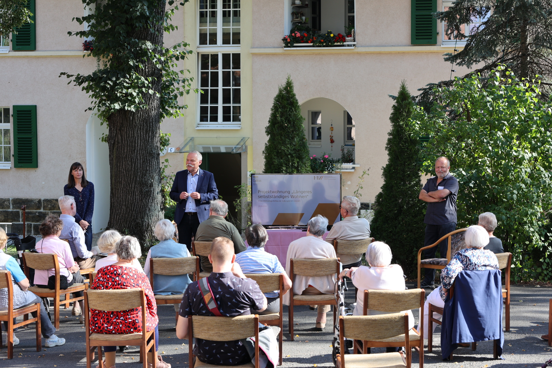 The residents of the residential complex listen intently to the explanations of Prof. Böhme and Mr. Beine.