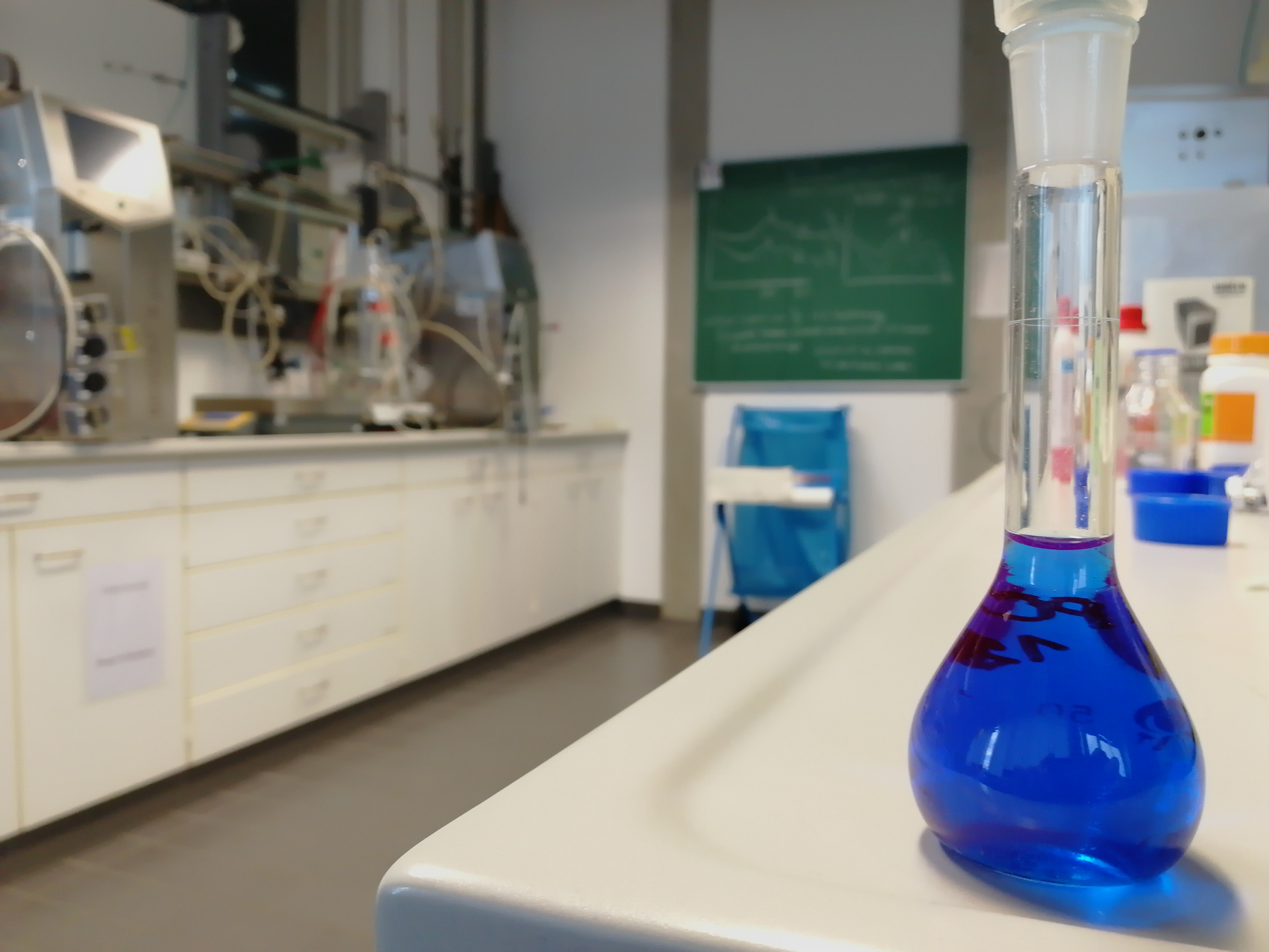 Laborbank mit blauer Flüssigkeit in Maßkolben