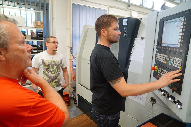 Das Bild zeigt, wie ein Studierender CNC-Daten an der Bedientafel eines CNC-Beabeitungszentrums editiert.
