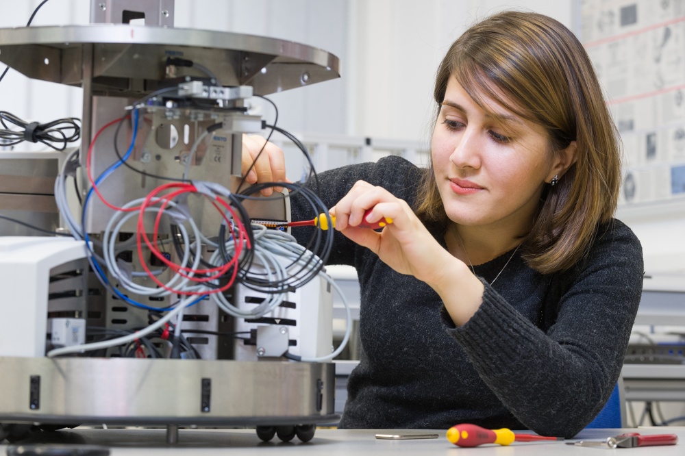 Frau arbeitet an elektrischen Bauteilen