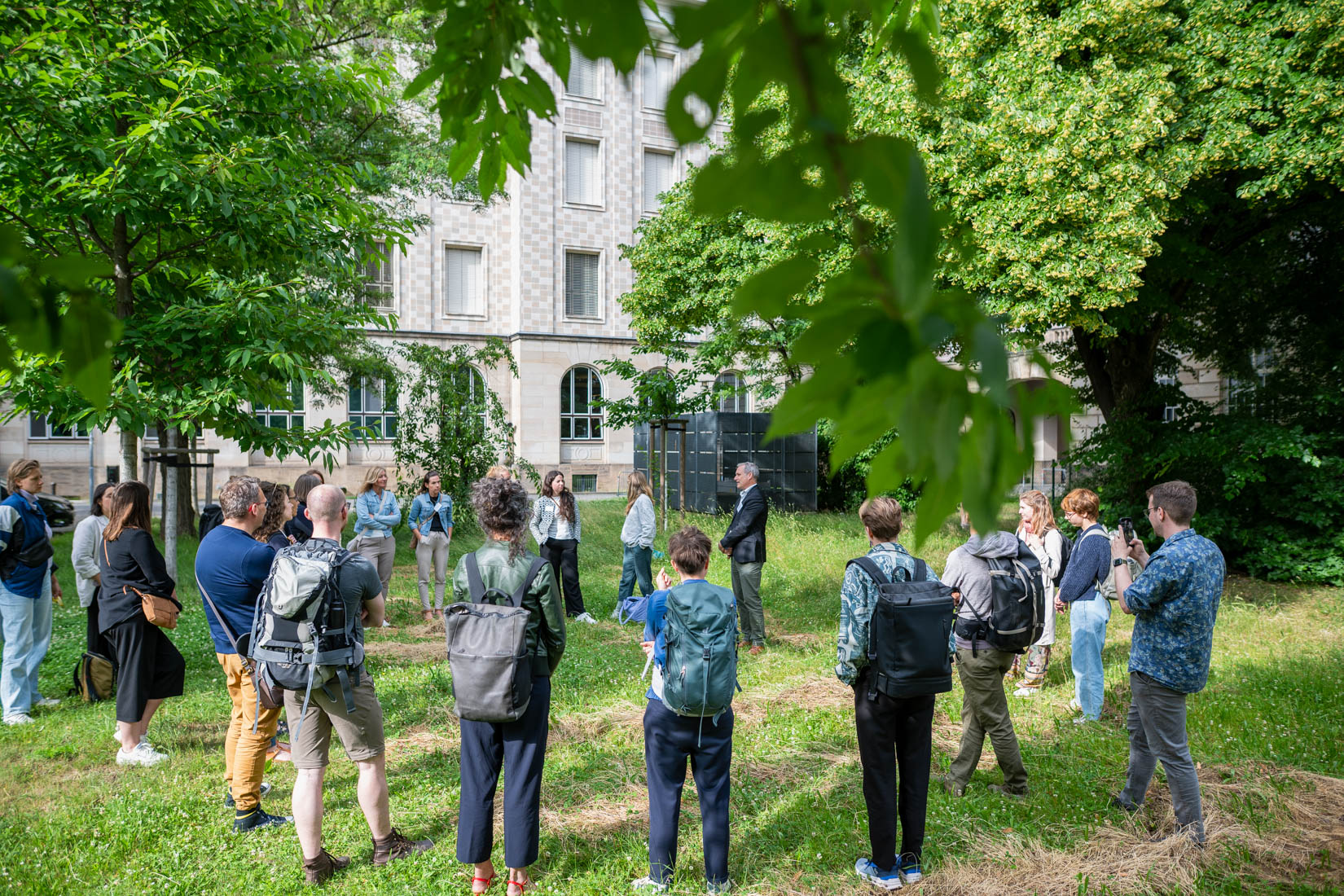 Menschen stehen im Kreis auf einer Wiese