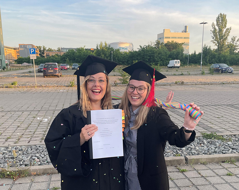 Porträt von Franziska Bielefeldt und Lisa Obst mit ihren Promotionsurkunden in der Hand