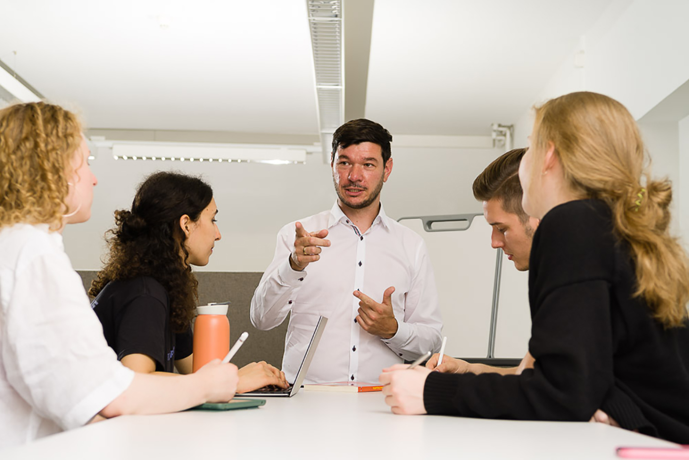 Lehrender mit Studierendengruppe