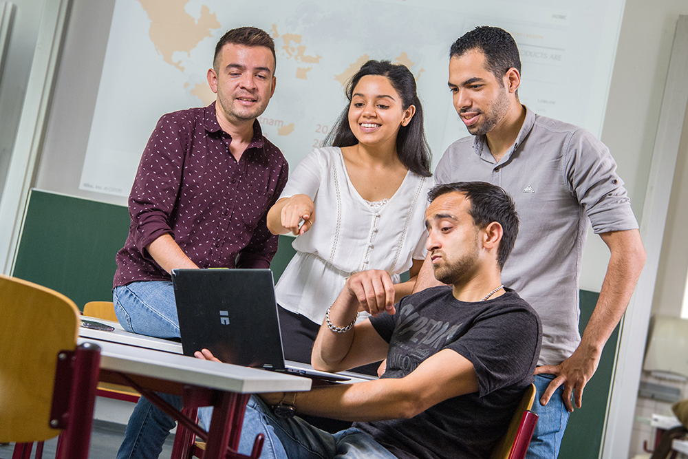 Alumni Ahmad Barakat mit seinen Mitstudierenden am PC