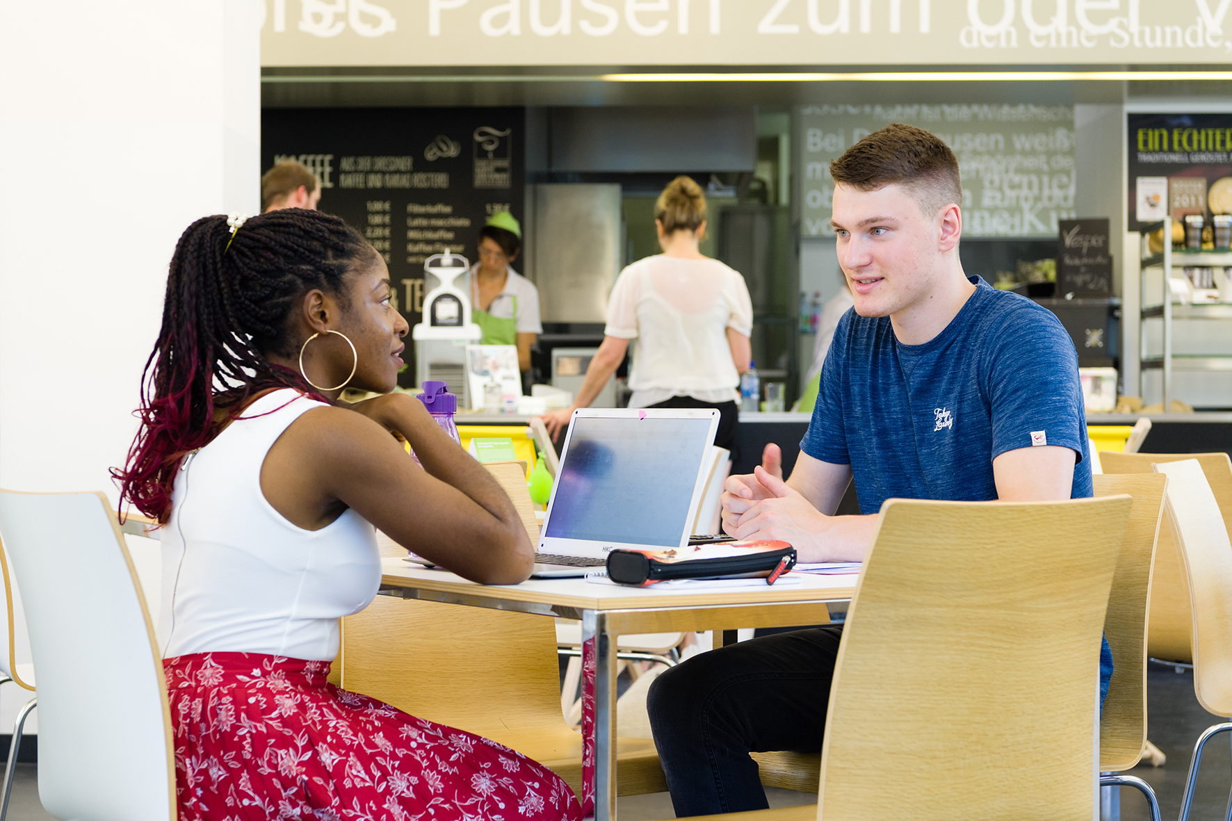 Studentin und Student sitzen am Tisch