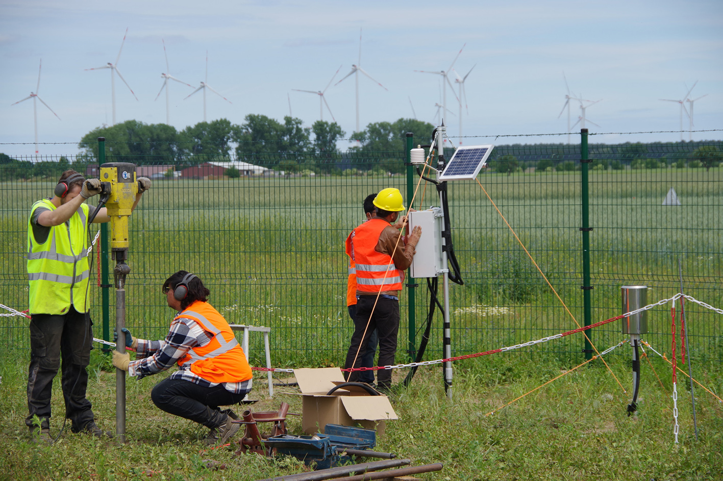 Wissenschaftler überprüfen die Klimastation auf dem Solarfeld.