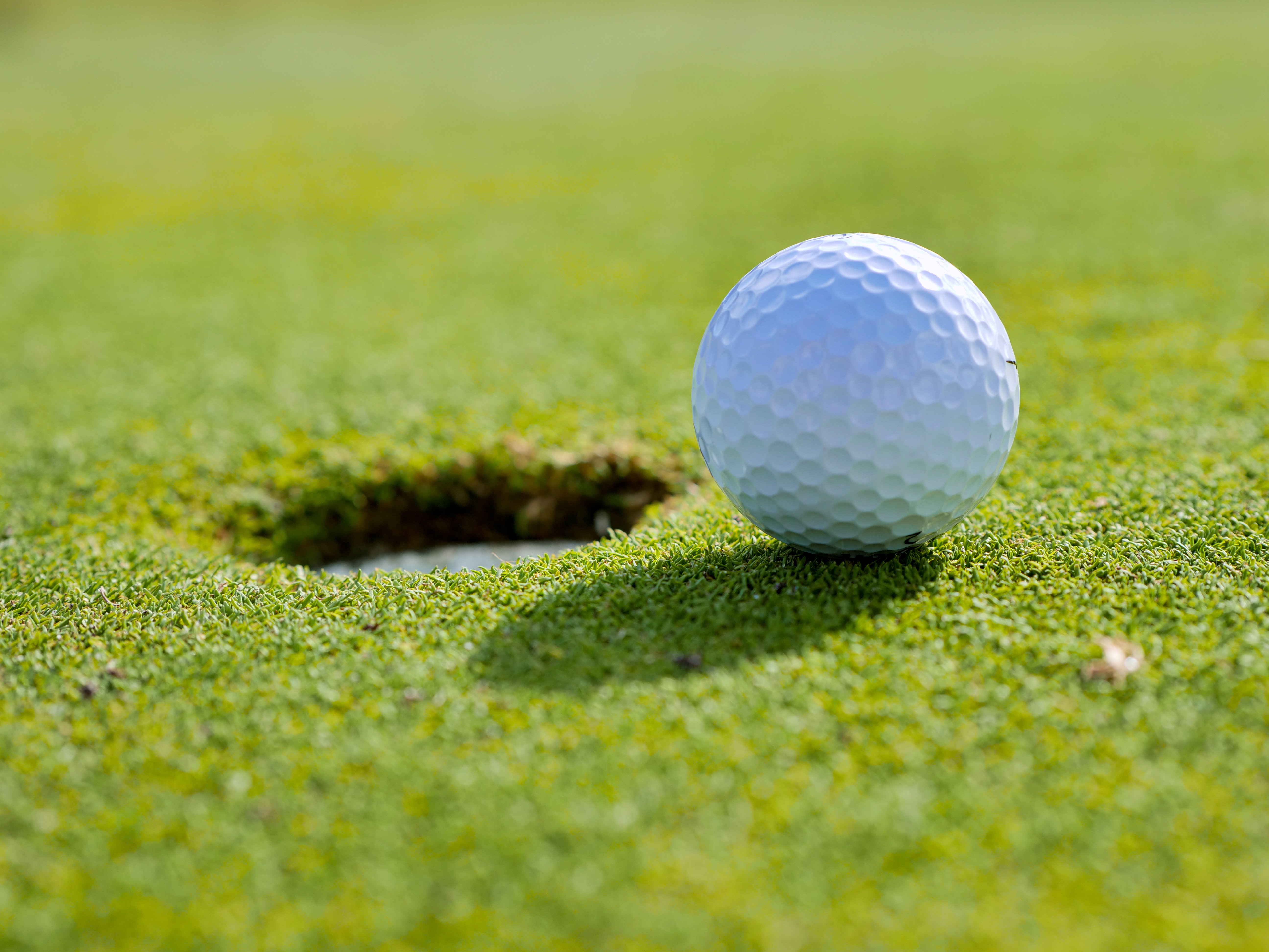 Golfball vor Loch