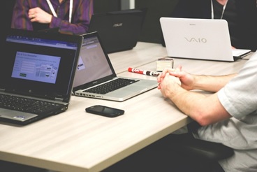 Menschen mit Laptops am Tisch