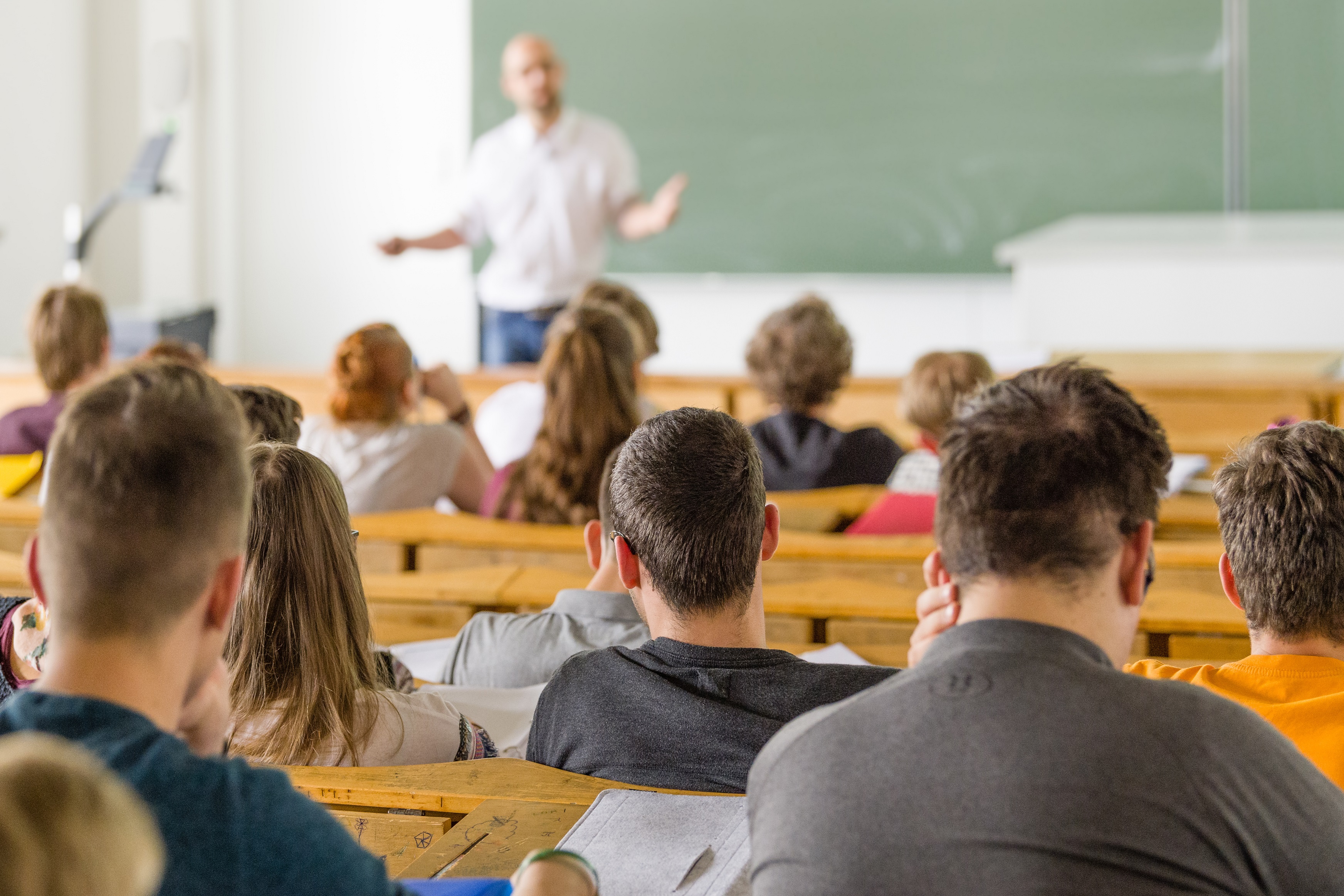 View into the lecture hall with students and a professor