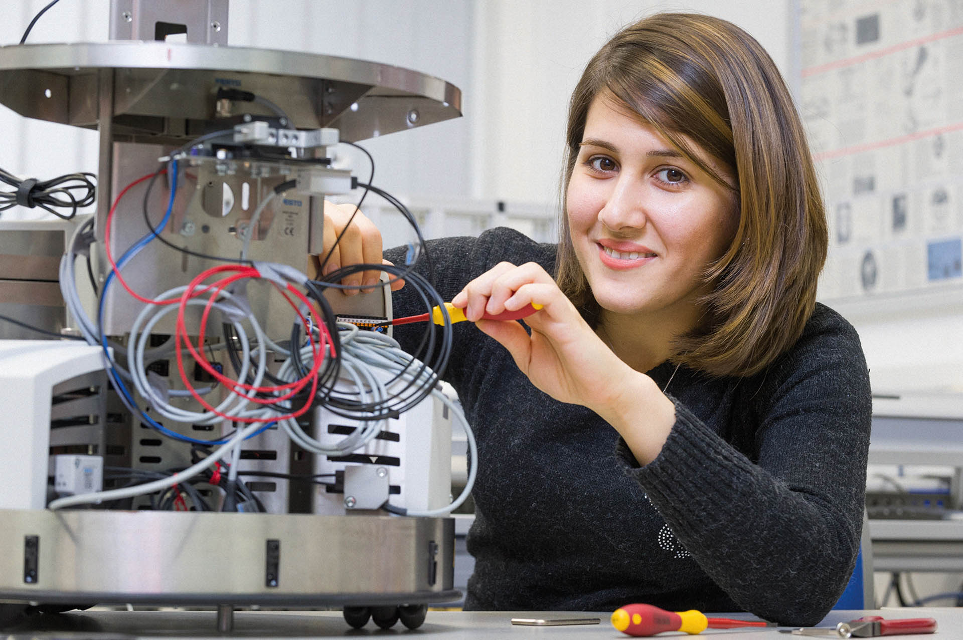 Studentin installiert elektrische Komponenten