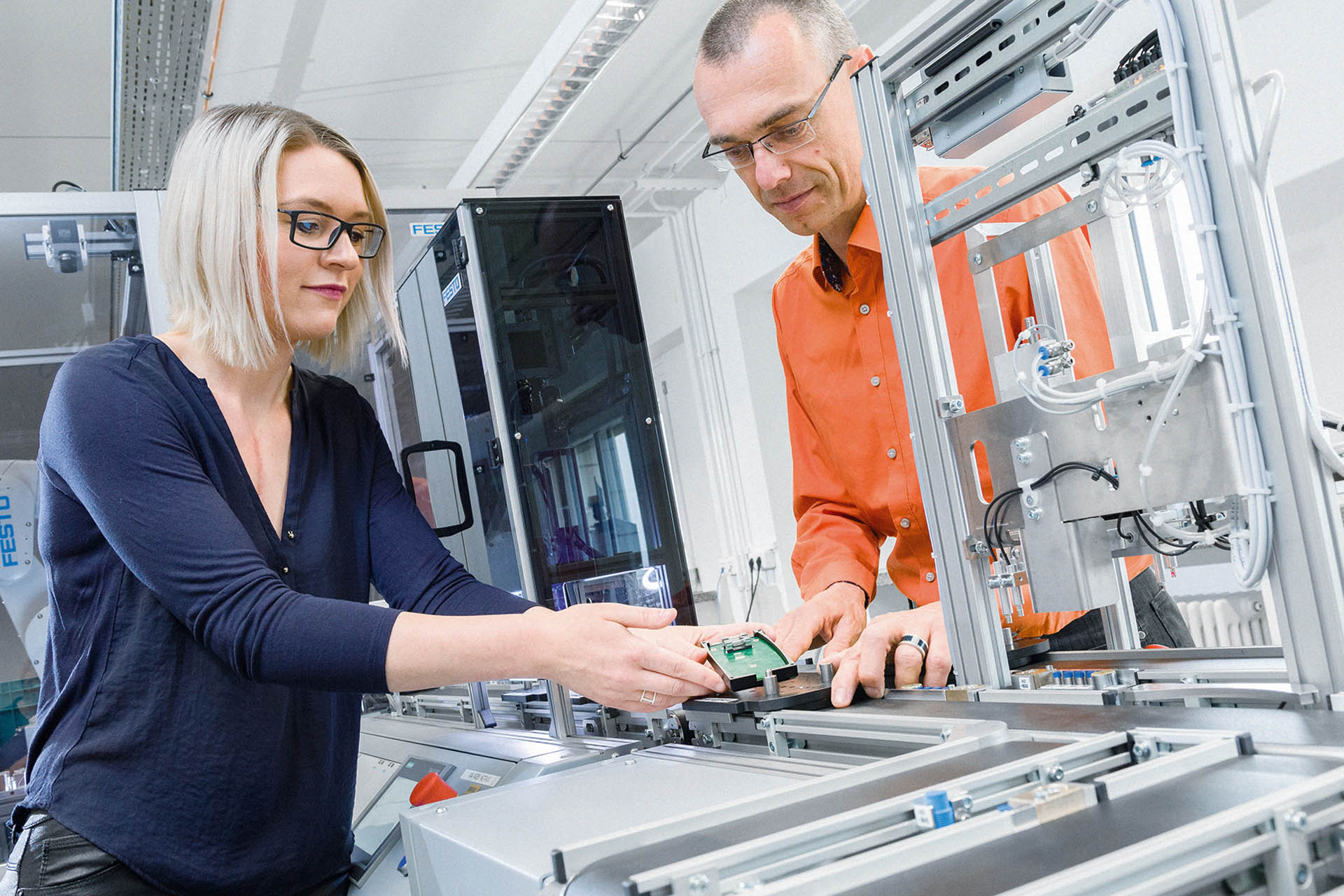 Studentin und Laborassistent bereiten einen maschinellen Versuch vor