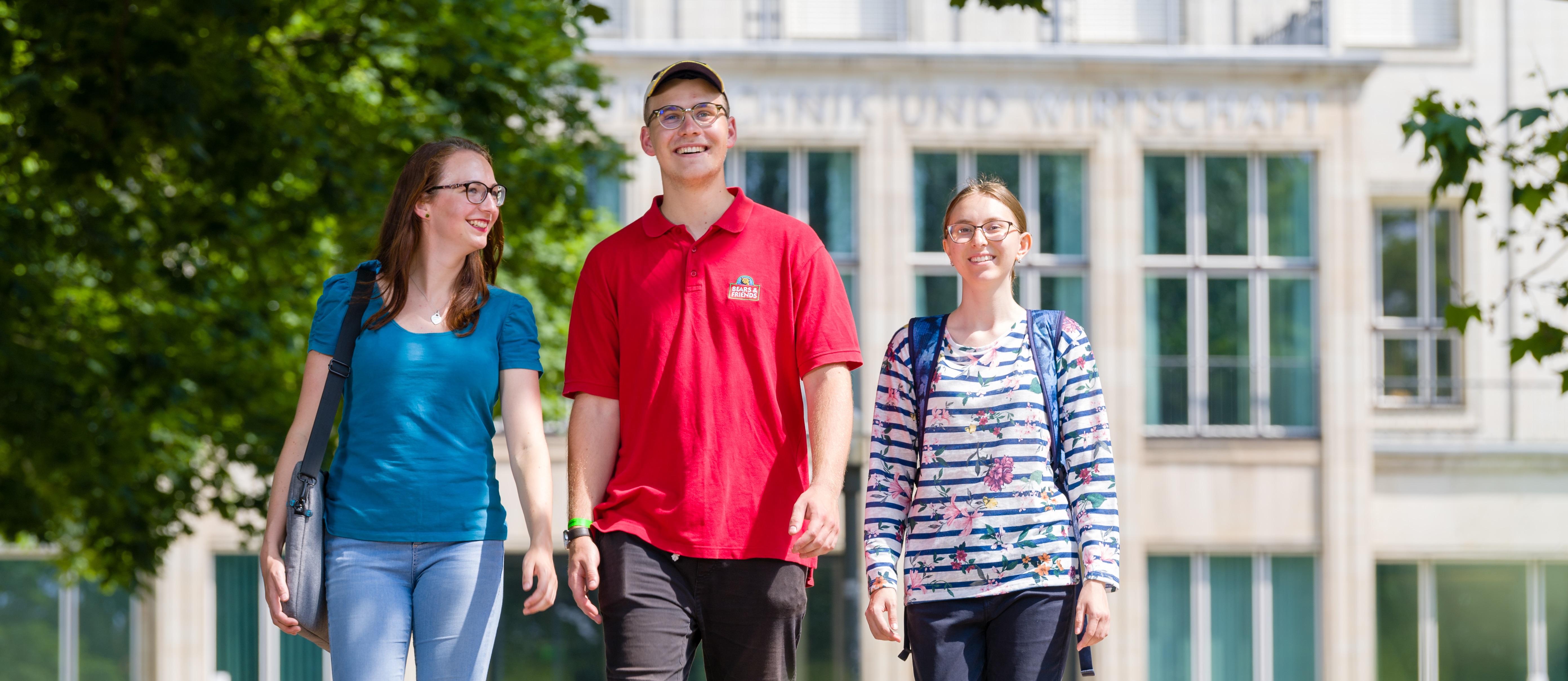 Studierende auf dem Weg vor dem Zentralgebäude