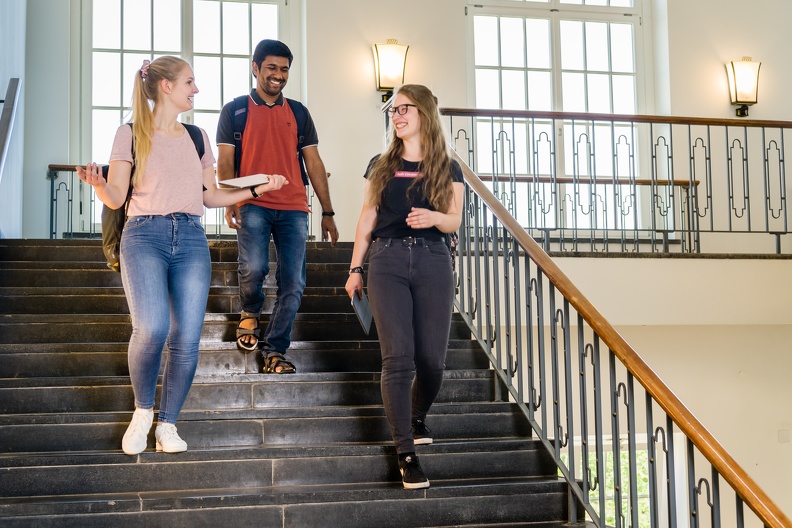 Drei Studierende auf der Treppe