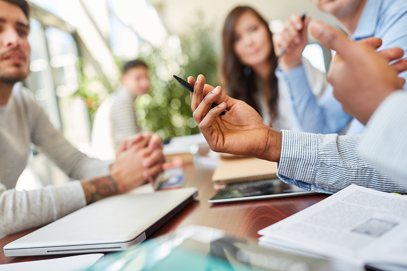 [Translate to English:] Hand mit Stift in der Hand gestikuliert in einem Workshop