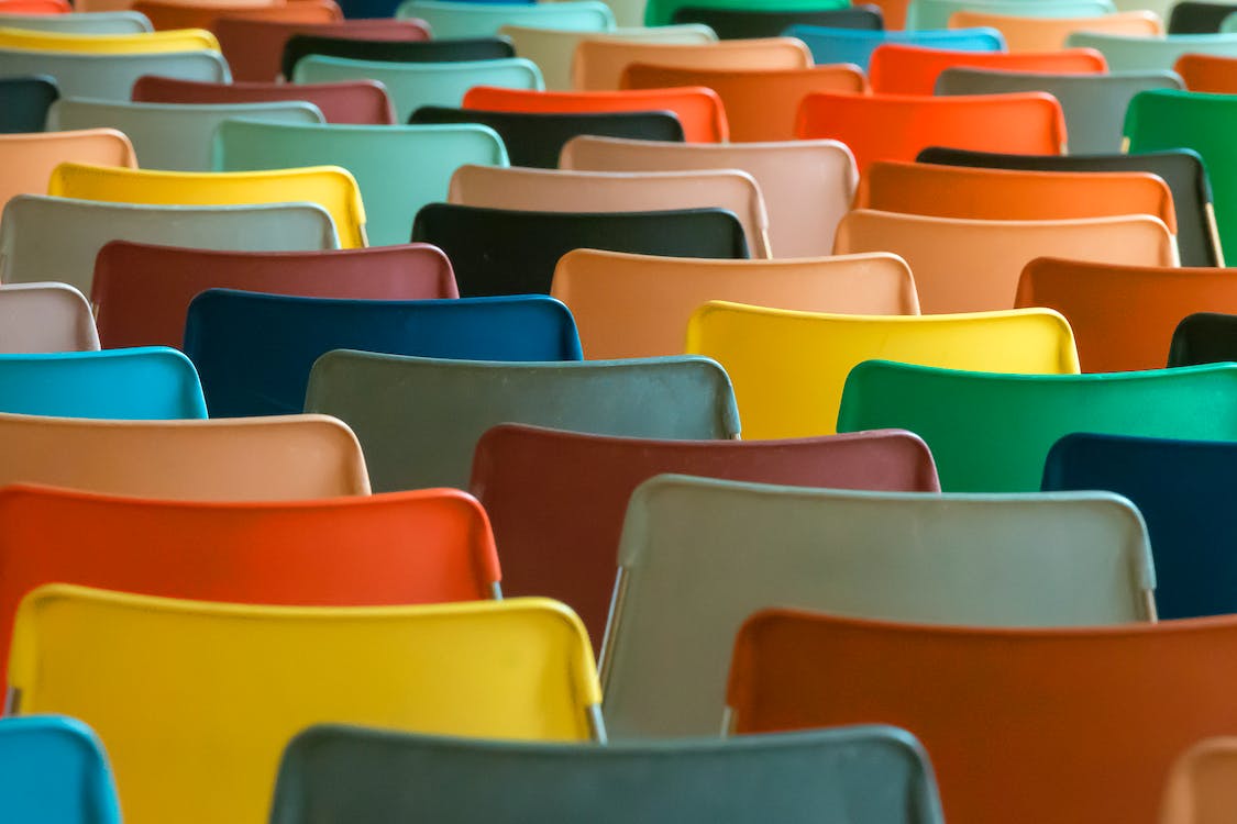 bunte Stuhlreihen symbolisieren Lehre und Wissensvermittlung