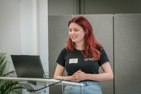 Eine Frau, stellt dem Publikum etwas vor.