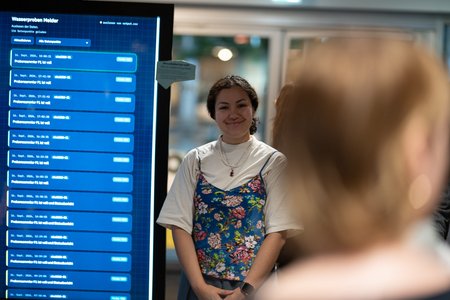 Frau steht vor Bildschirm mit Anzeige