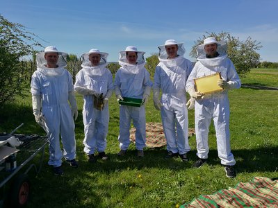 Fünf Personen in Imkerkluft