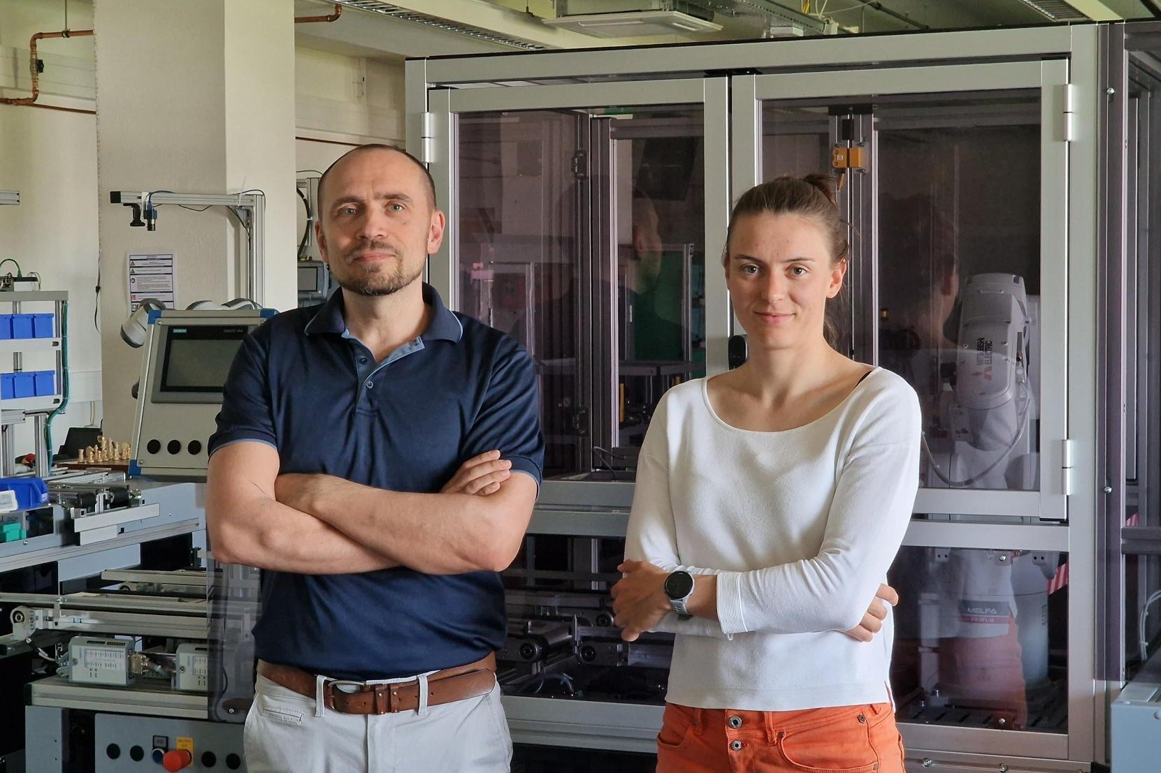 Miarbeitende Saskia und Eugen vor der Industrie 4.0 Modellfabrik