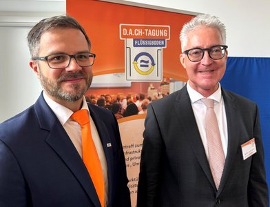Zwei Männer vor einem Rollup