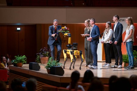 Auszuzeichnende auf der Bühne mit Roboterhund