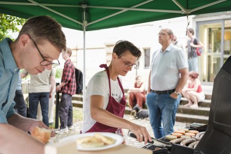 Menschen, die an einem Grill stehen.