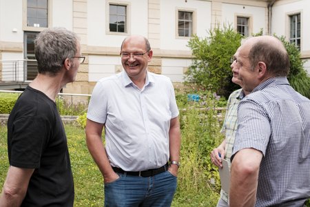 Drei Männer, die sich miteinander unterhalten.