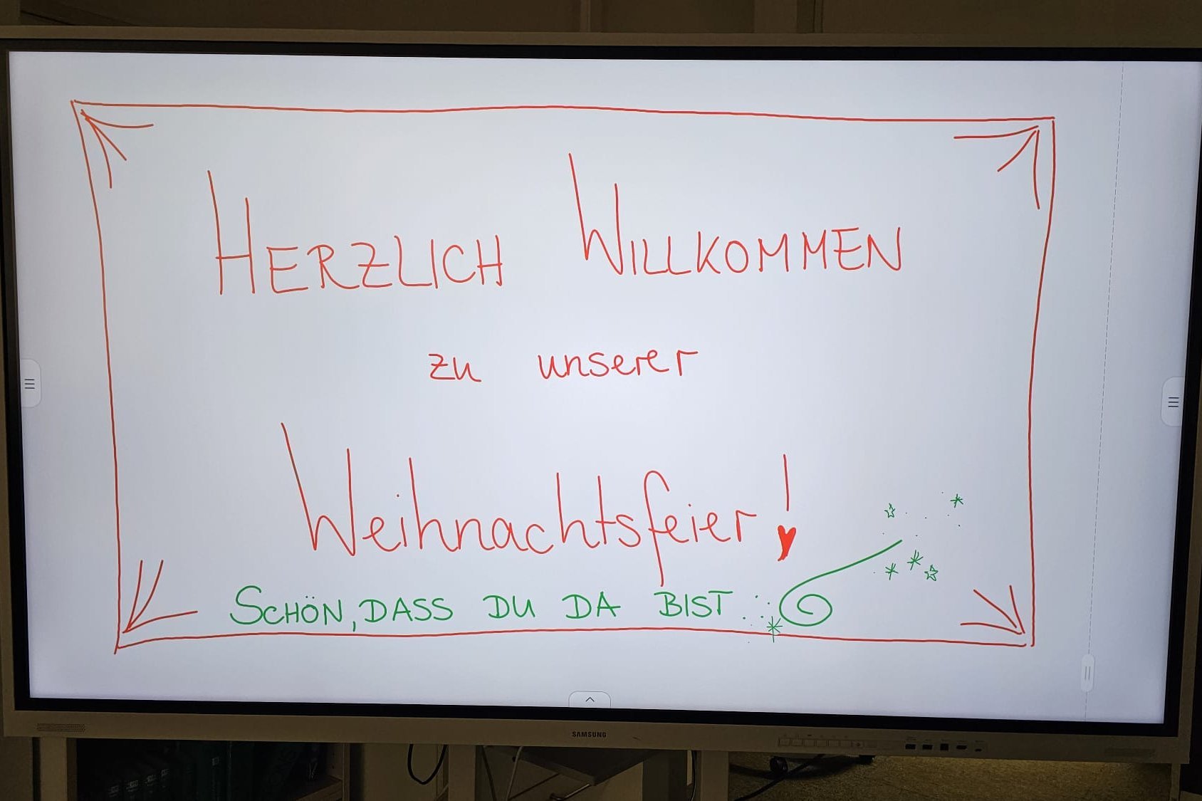 Weihnachtsfeier ZFS für DaF Studierende Smartboard mit der Aufschrift "Herzlich Willkommen zu unserer Weihnachtsfeier"