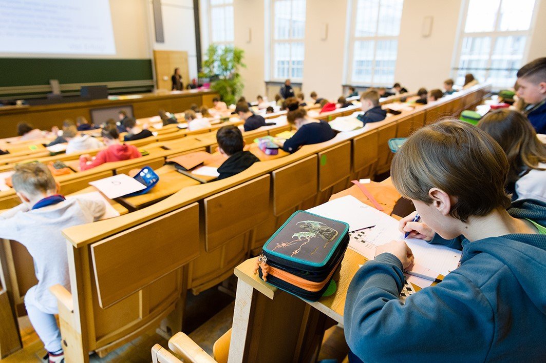Mehrere Schülerinnen und Schüler im Hörsaal