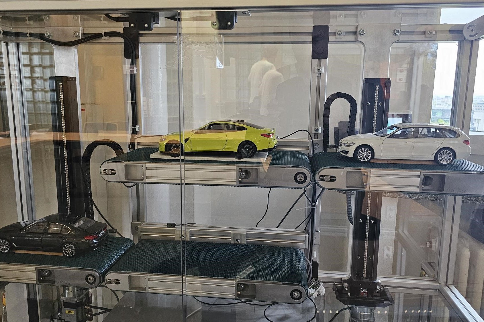Demonstrator für entwickelte Technologie, mehrere Miniaturautos stehen auf verschieden hohen Rollbändern