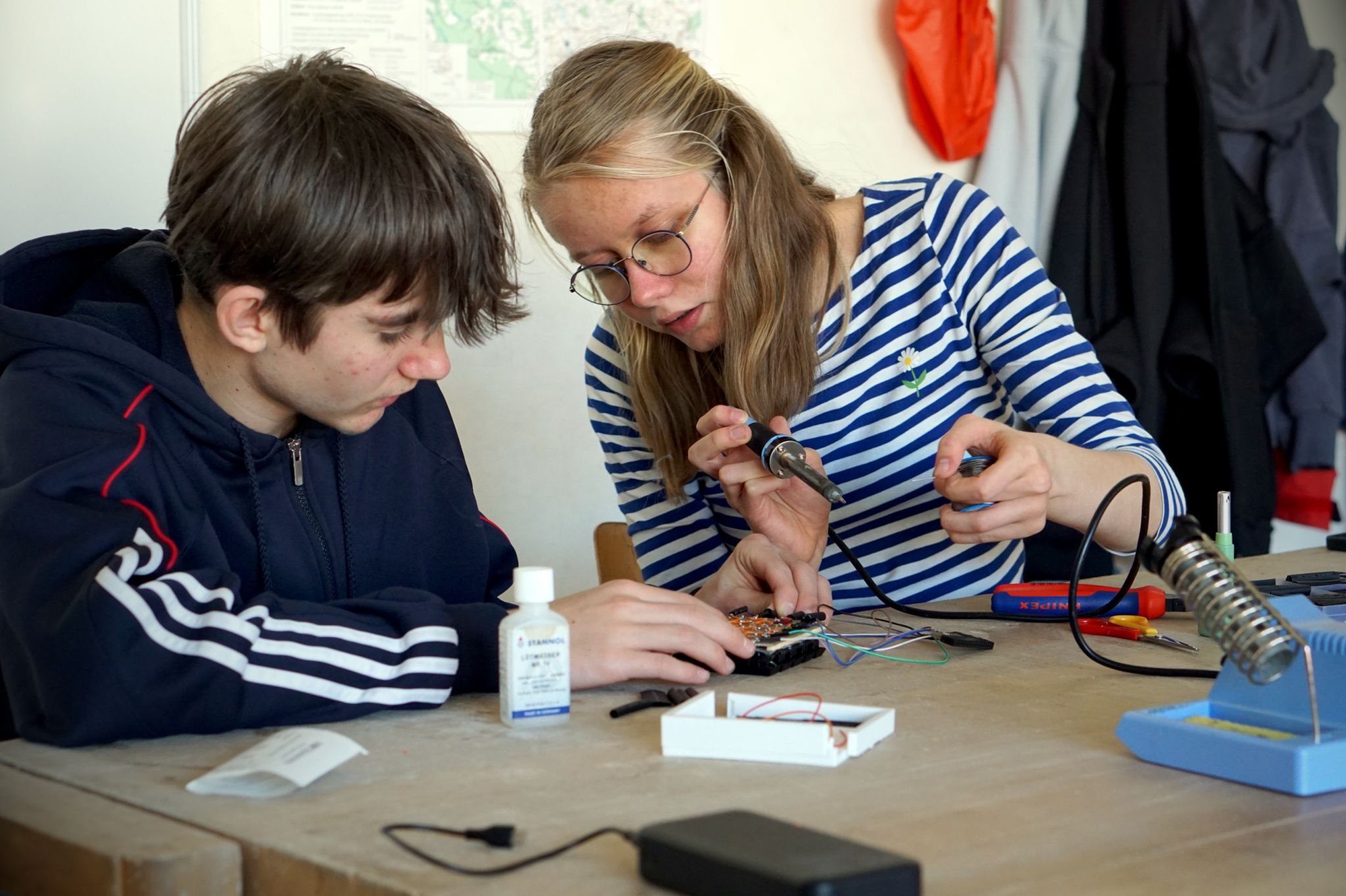 Schülerin und Schüler beim Löten von Elektronik