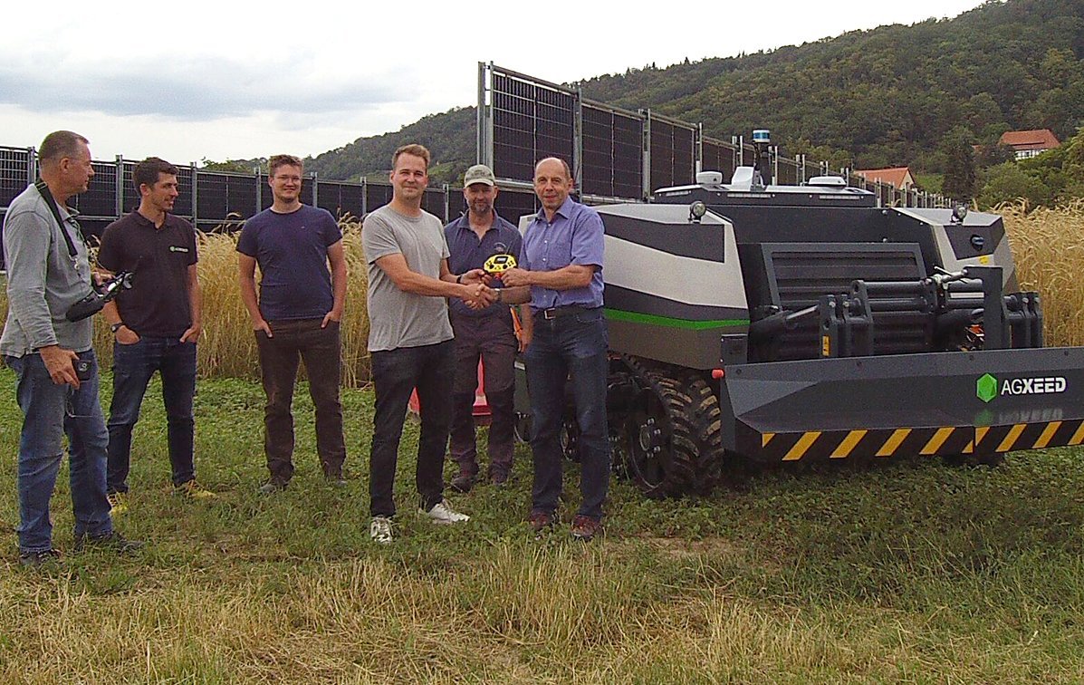 Menschen in der Agri-PV-Anlage in Pillnitz vor einem Traktor