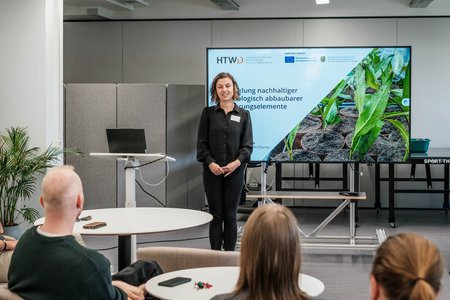 Eine Frau, stellt dem Publikum etwas vor.