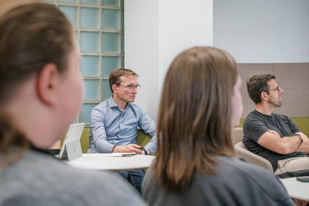 Menschen, die einer Rednerin zuhören.