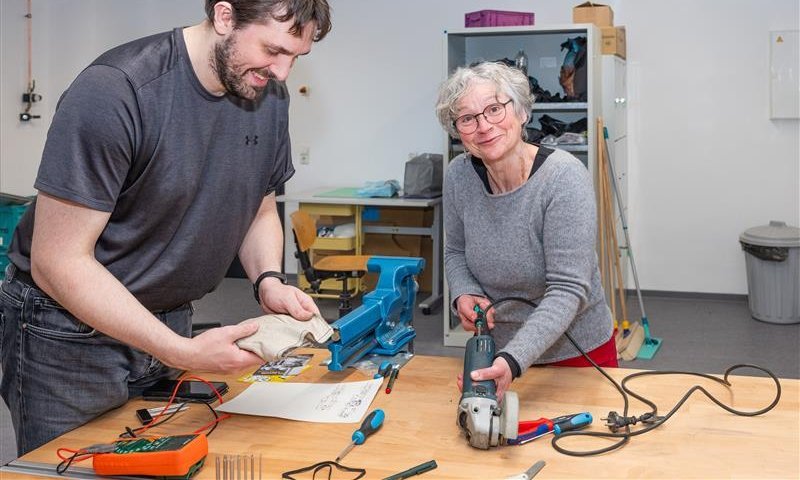 Zwei Menschen reparieren einen Winkelschleifer in der LAb X Werkstatt