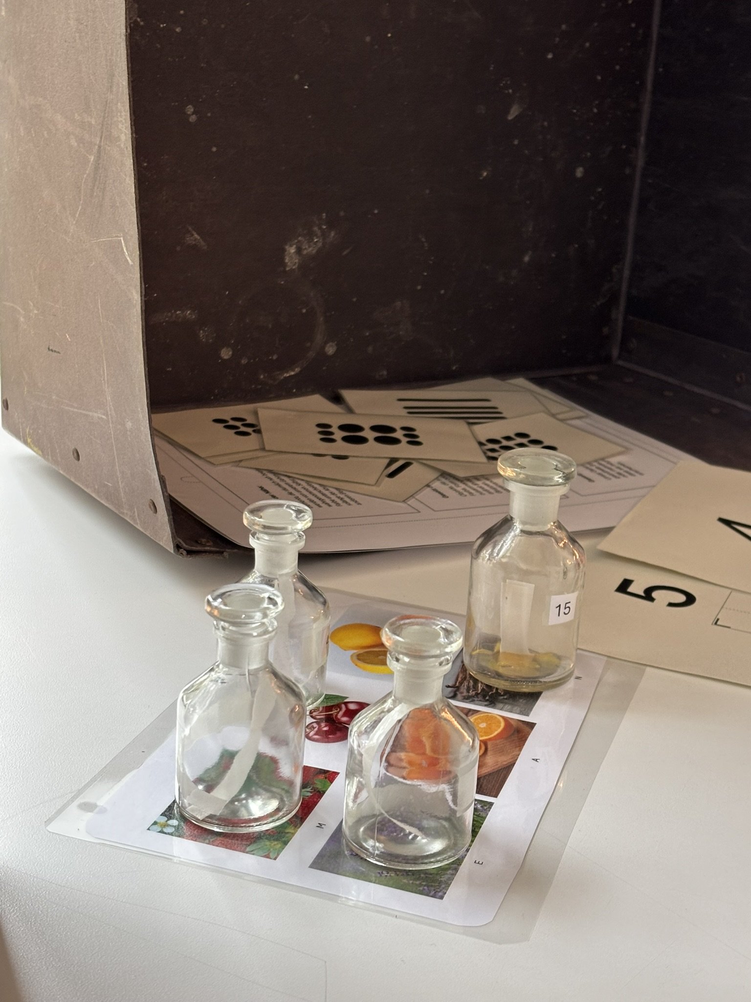 Glasfläschchen vor einer Kiste