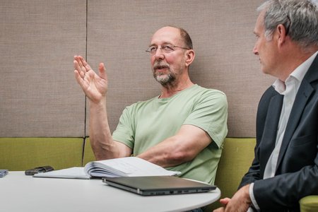 Ein Mann, der mit den Vortragenden diskutiert.