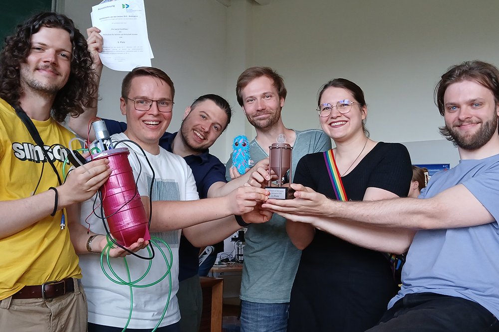 6 Menschen halten einen Pokal