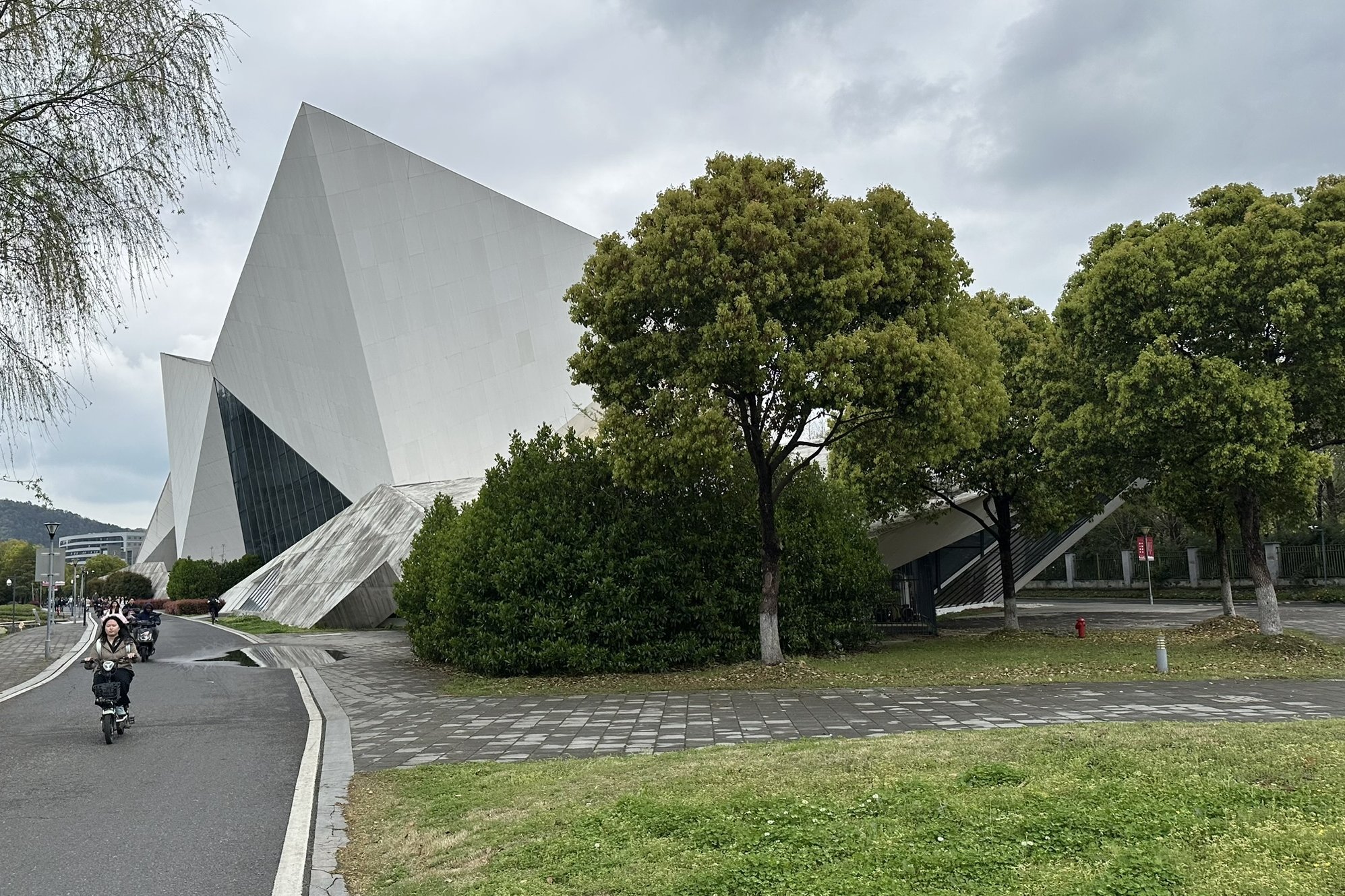 Campusgebäude im Hintergrund und Fußgänger