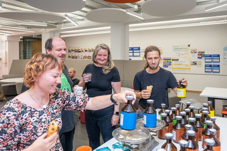 Menschen stehen vor einer Waage und probieren Gewichte aus