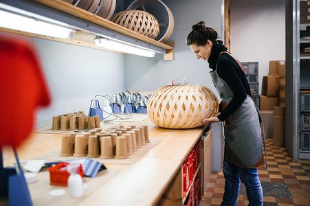 [Translate to English:] Designerin arbeitet an einer Lampe