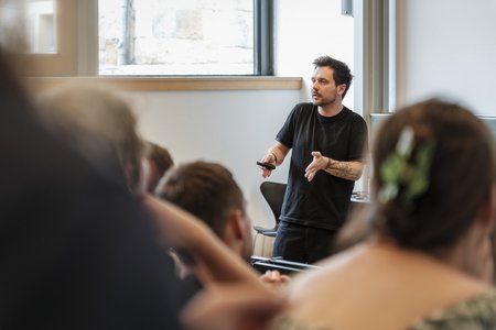 Ein Mann, der vor Menschen spricht.