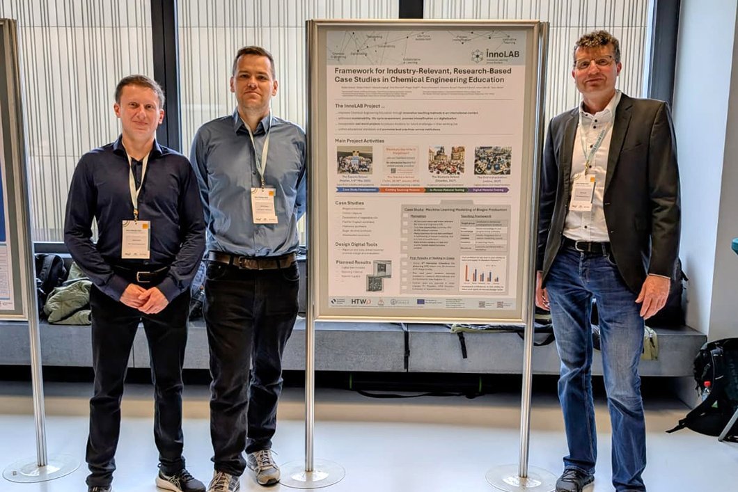 Drei Männer stehen neben einem Wissenschaftsplakat