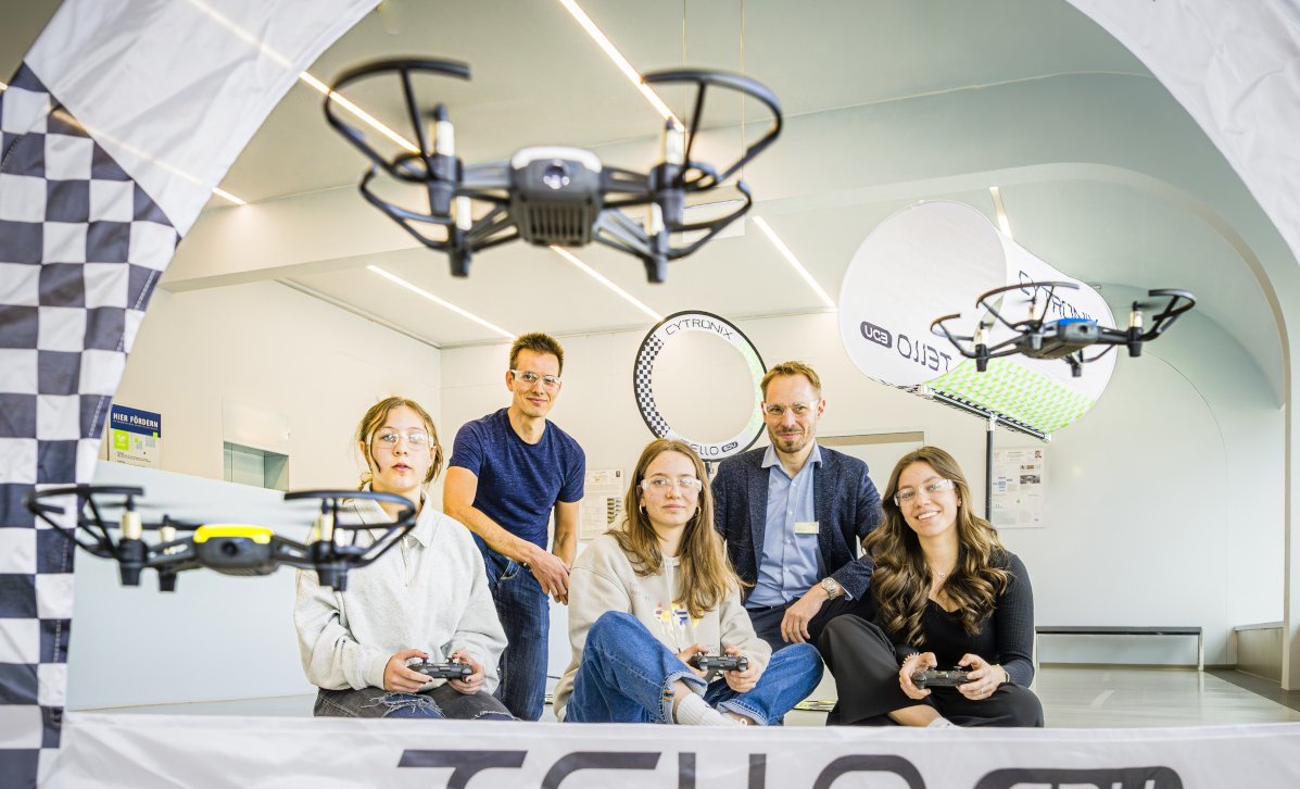 Mädchen und Forscherteam steuern Drohne