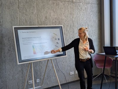Frau präsentiert an Bildschirm