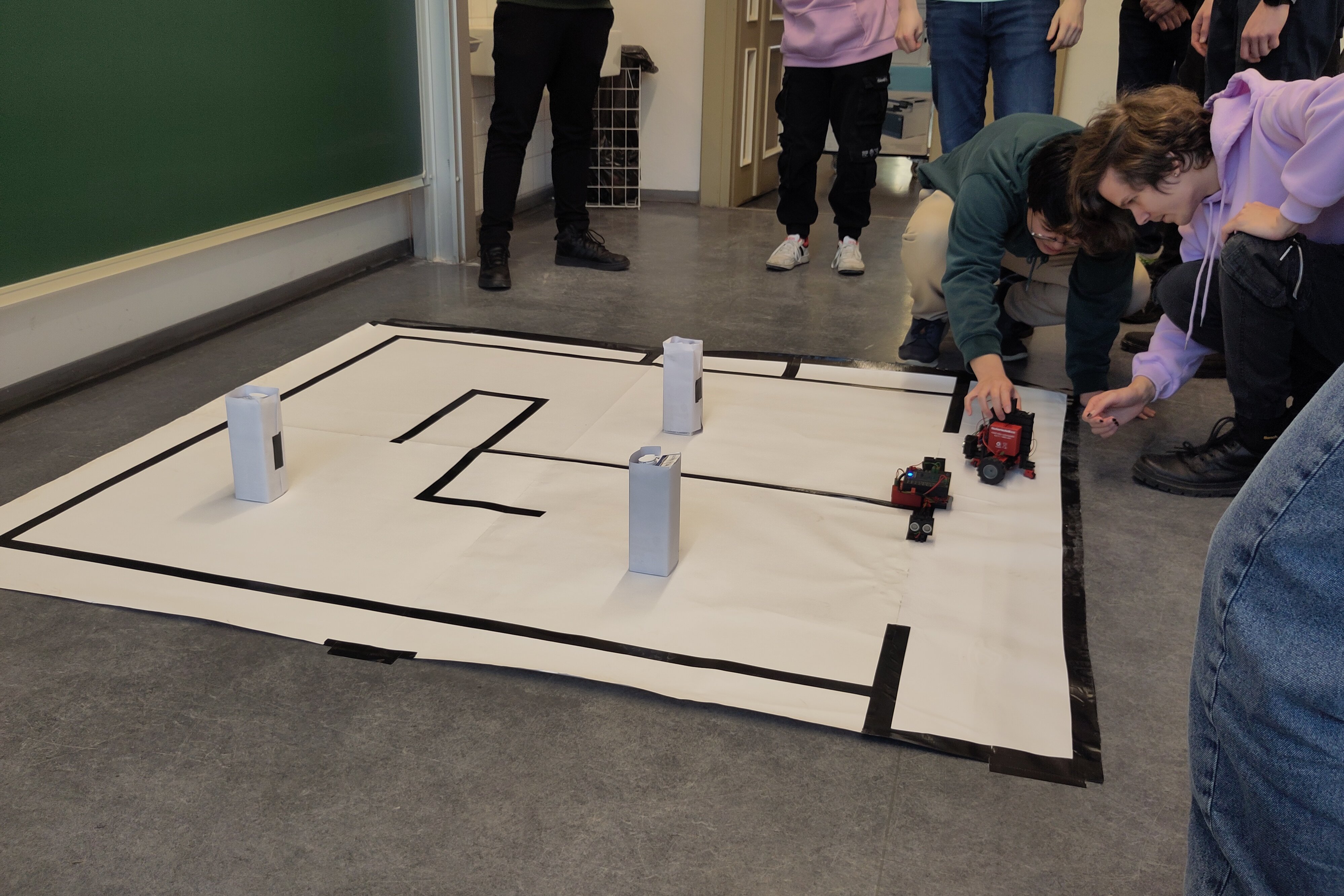 Studierende beim Platzieren des Roboters auf den Parcour