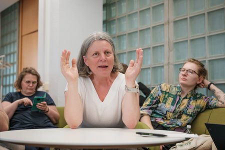 Eine Frau, die mit den Rednern diskutiert.