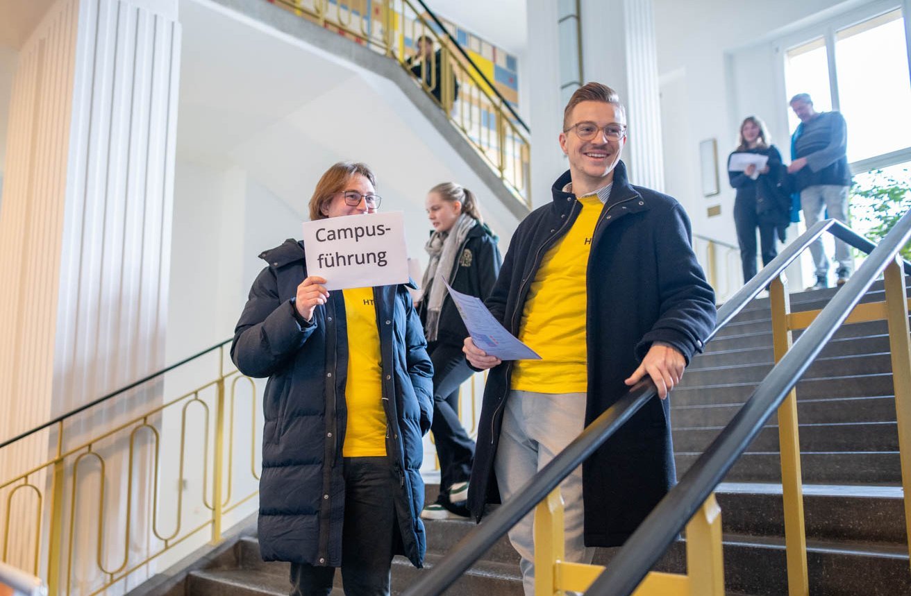 Studenten mit Schild "Campusführung"
